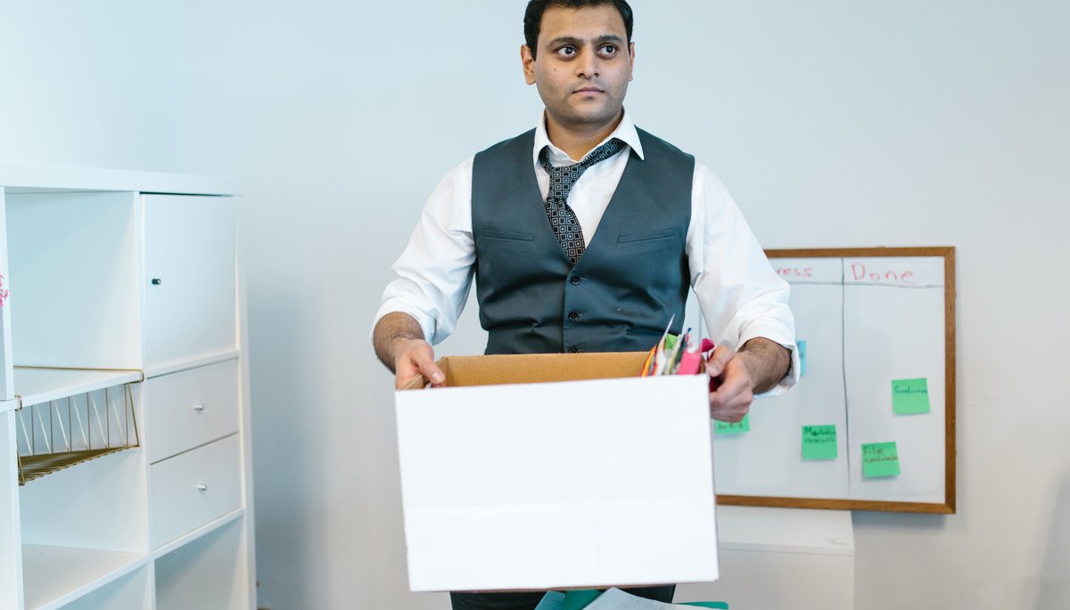 Professional carrying a box of belongings out of the office