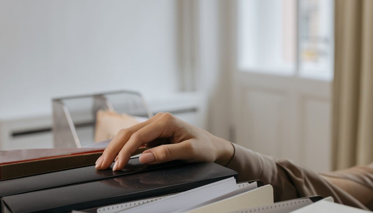 Hand placed on a file folder of documents