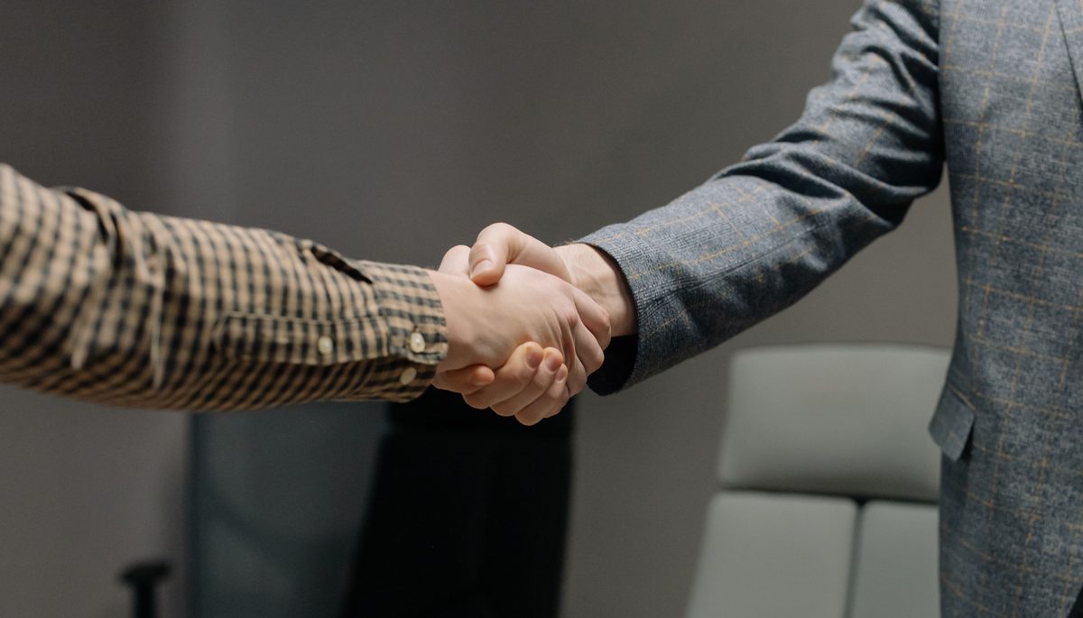 Two professionals shaking hands after a job offer
