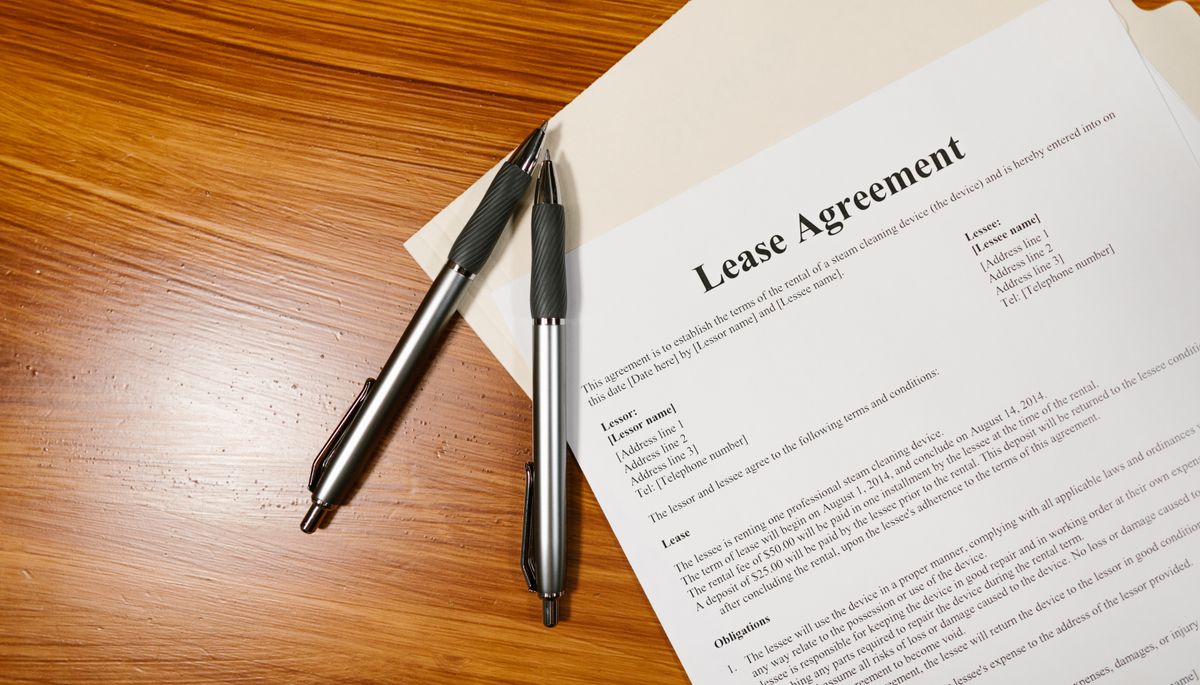 Lease agreement document with pens on a wooden desk