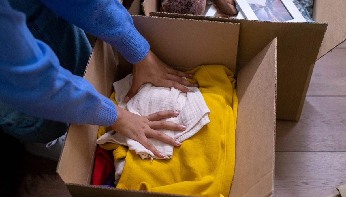 Person packing personal belongings into a box